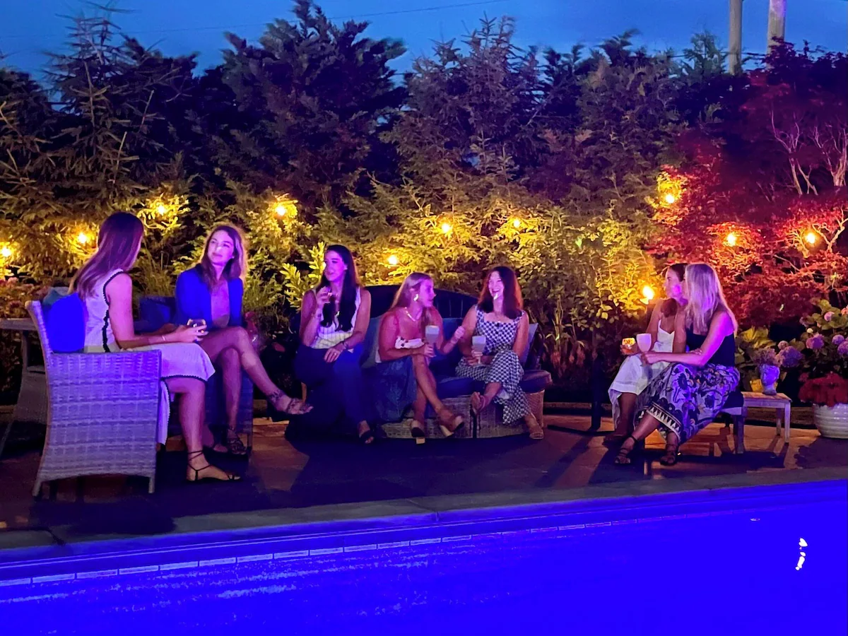 Stowaways poolside after dark, the terrace and gardens lit up for the evening.